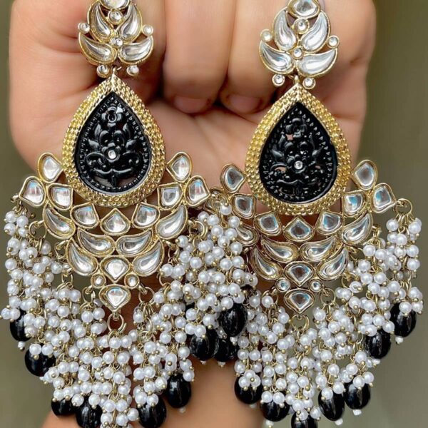 Beautiful premium quality long earrings made of kundan and white small pearls and black colour pearls. The metal is alloy and the plating is gold.