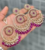Beautiful premium quality reverse Ad Boysenberry ruby coloured artificial stone, pearl earrings and tilak made of base metal alloy and gold plated and presented in hand holding