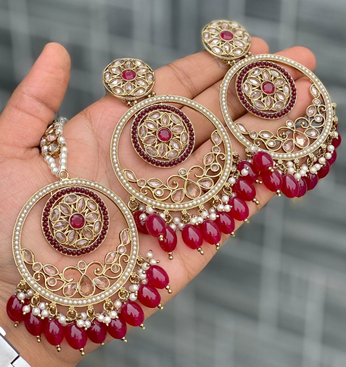 Beautiful premium quality reverse Ad Burgundy coloured artificial stone, pearl earrings and tilak made of base metal alloy and gold plated and presented in hand holding