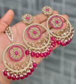 Beautiful premium quality reverse Ad Carmine dark pink coloured artificial stone, pearl earrings and tilak made of base metal alloy and gold plated and presented in hand holding