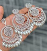 Beautiful premium quality reverse Ad Diamond white coloured artificial stone, pearl earrings and tilak made of base metal alloy and gold plated and presented in hand holding