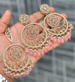 Beautiful premium quality reverse Ad melon pink coloured artificial stone, pearl earrings and tilak made of base metal alloy and gold plated and presented in hand holding