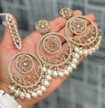 Beautiful premium quality reverse Ad white coloured artificial stone, pearl earrings and tilak made of base metal alloy and gold plated and presented in hand holding