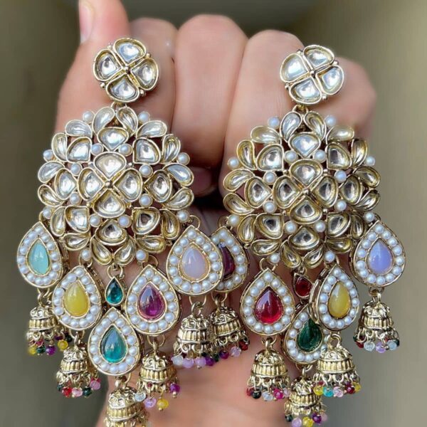 Beautiful Kundan and multicolour pearl earrings are made of alloy and have gold colour plated on them, which are presented and held in the hands.